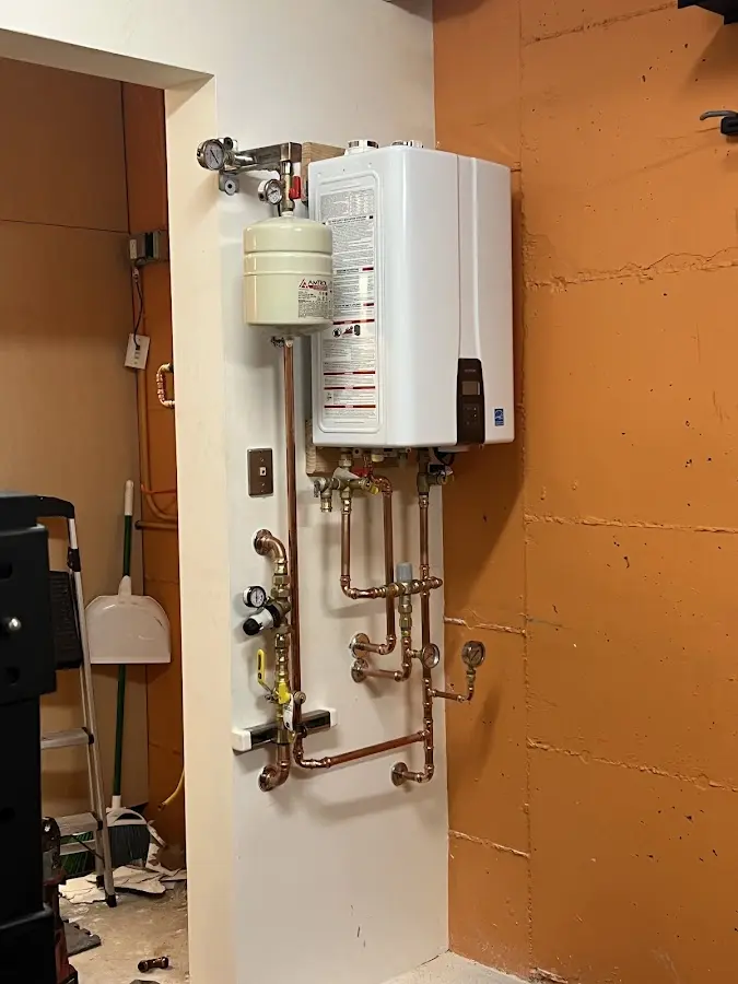 Plumbing technician inspecting water heater connections in North Fort Lewis